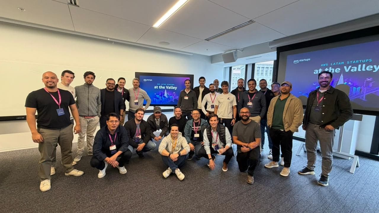 Around twenty attendees posed in front of the screens for “AWS LATAM Startups at the Valley”.